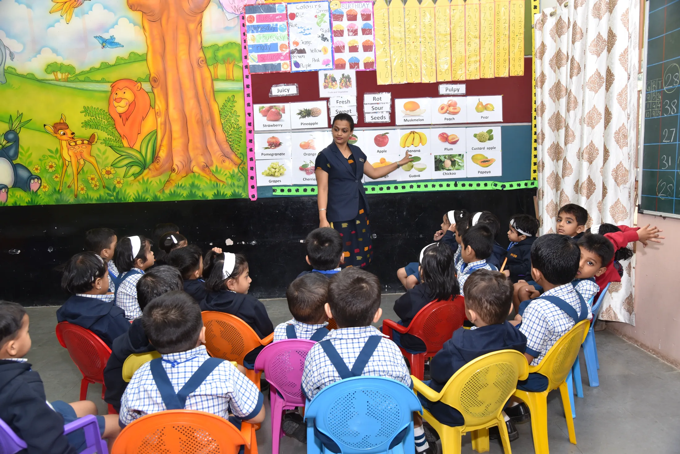 Pre-primary children on coloured chairs in their classroom